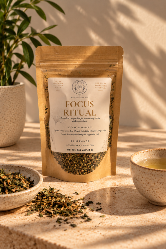 Focus Ritual kraft pouch on a sunlit stone surface with a potted plant, loose tea and a cup of green tea